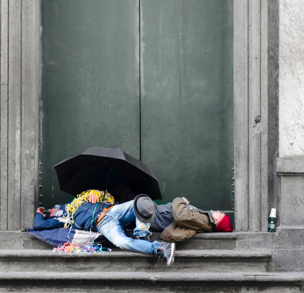 Persone che dormono su una soglia.
